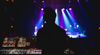 The silhouette of an audio engineer mixing