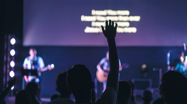 A man lifts his hands during a worship service